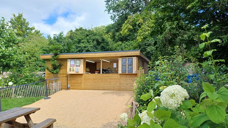 An outdoor cabin for refreshments surrounded by greenery
